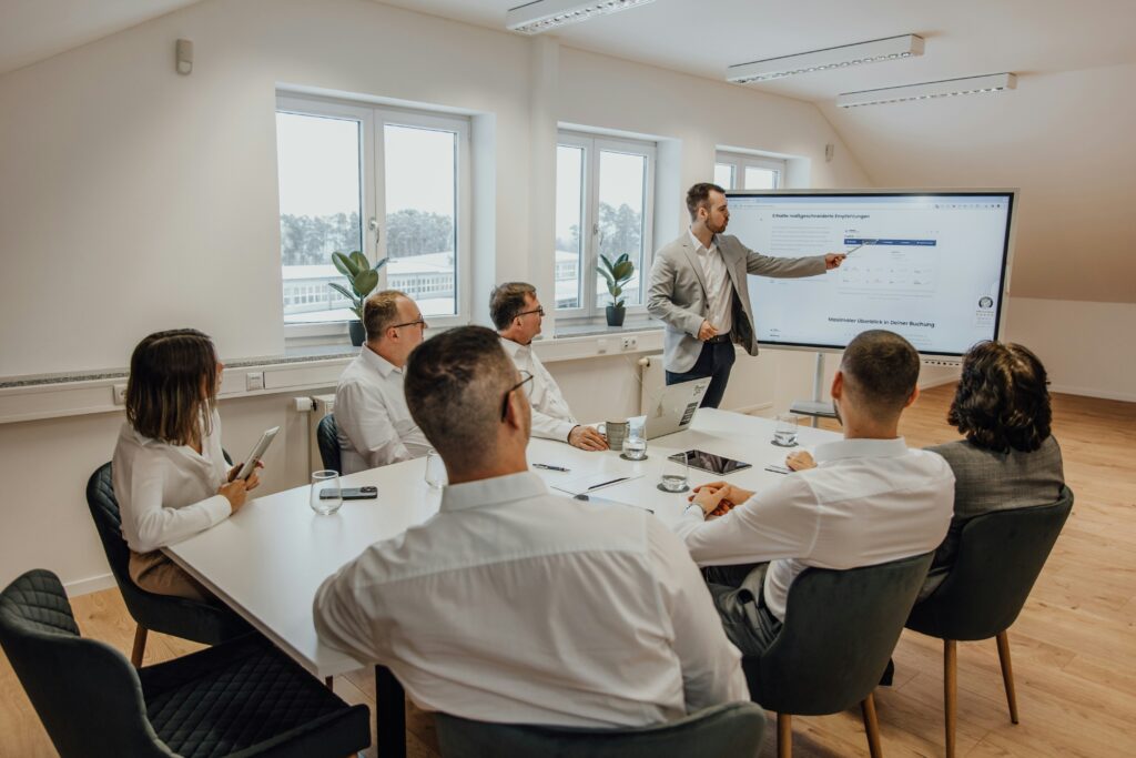 people in room around table in a meeting